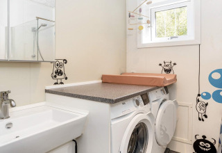 Waskamer in een 5-sterren vakantiehuis in Øster Assels met wasmachines en vrolijke monsterstickers op de muur.