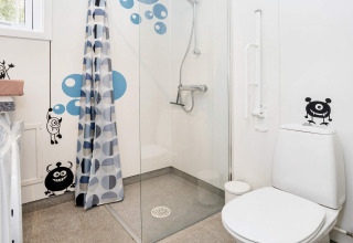 Bagno nella casa vacanze 5 stelle a Øster Assels, Danimarca, con adesivi mostri e area doccia.