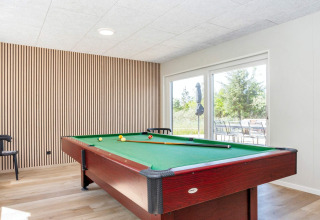 Tavolo da biliardo moderno in sala luminosa con pavimento in legno presso casa vacanze 5 stelle a Øster Assels.