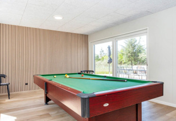 Table de billard moderne dans une salle lumineuse au sol en bois au sein d'une maison 5 étoiles à Øster Assels.