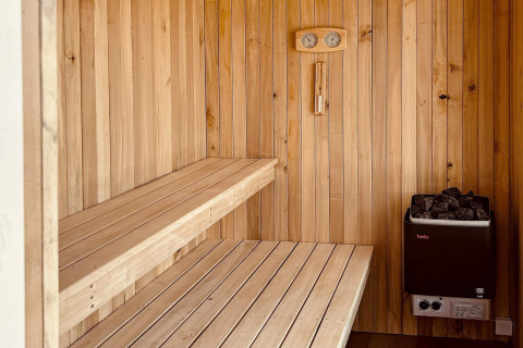 Moderne Sauna mit Holzbänken und Ofen im '5 star holiday home in Øster Assels' in Dänemark.