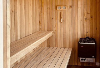 Moderne Sauna mit Holzbänken und Ofen im '5 star holiday home in Øster Assels' in Dänemark.