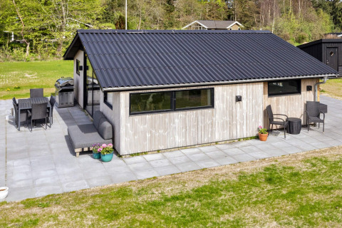 Esterno di una casa vacanze 4 stelle a Løgstør, Danimarca, con patio e area salotto all'aperto.