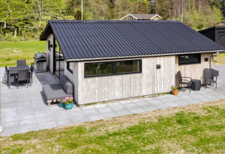 Außenansicht eines modernen Ferienhauses in Løgstør, Dänemark, mit Terrasse und Sitzgelegenheiten.