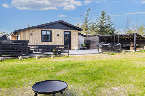 Modern 4-sterren vakantiehuis in Løgstør, Denemarken, met terras, tuin en overdekte eetruimte buiten.