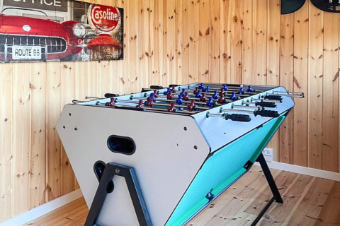 Ein moderner Tischkicker steht in einem holzgetäfelten Raum im 4-Sterne-Ferienhaus in Løgstør, Dänemark.