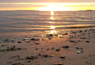 Atardecer sobre el mar desde la playa en una casa de vacaciones de 4 estrellas en Løgstør, Dinamarca.