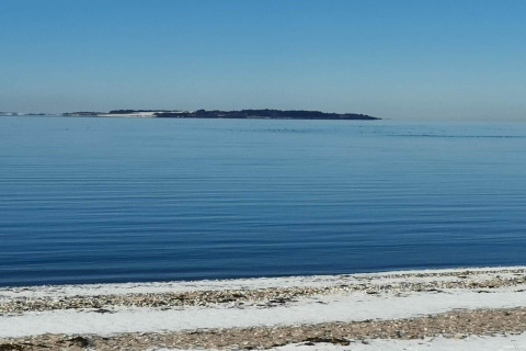 Vue sur la mer calme et une île au loin, prise depuis la plage de 4 star holiday home à Løgstør, Danemark.