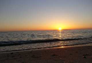 Zonsondergang boven zee gezien vanaf het strand bij 4 star holiday home in Løgstør, Denemarken.