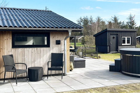 Terrazza esterna di una casa vacanze 4 stelle a Løgstør, Danimarca, con sedie e ambiente naturale moderno.