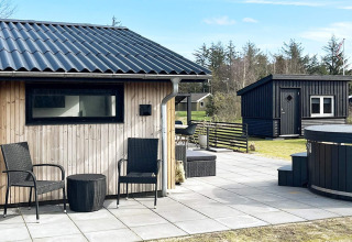 Außenterrasse eines 4-Sterne-Ferienhauses in Løgstør, Dänemark, mit Sitzgelegenheiten und modernem Look.