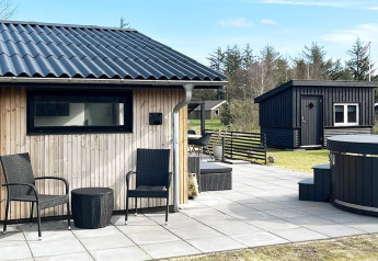 Terraza exterior en una casa de vacaciones de 4 estrellas en Løgstør, Dinamarca, con asientos y bonitas vistas.