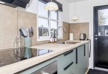 Cuisine moderne dans une maison de vacances 4 étoiles à Løgstør, Danemark, avec équipements élégants.
