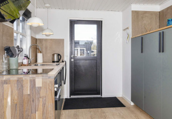 Moderne keuken in een 4-sterren vakantiehuis in Løgstør, Denemarken, met houtaccenten en veel kastruimte.