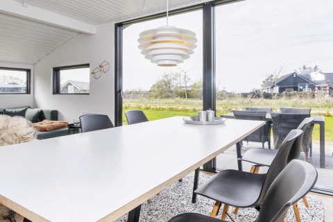 Helles Esszimmer in einem 4-Sterne-Ferienhaus in Løgstør, Dänemark, mit moderner Einrichtung und Blick nach draußen.