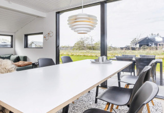 Lyst spisestueområde i en 4-stjernet feriebolig i Løgstør, Danmark, med moderne indretning og udsigt.