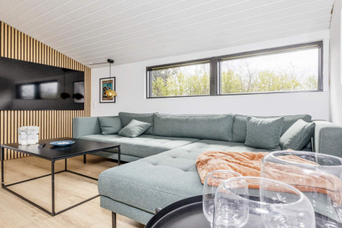 Soggiorno moderno e luminoso in una casa vacanze 4 stelle a Løgstør, Danimarca, con grande divano.