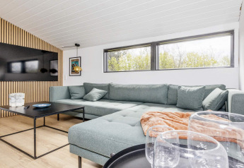 Lichte, moderne woonkamer in een 4-sterren vakantiehuis in Løgstør, Denemarken, met ruime hoekbank.