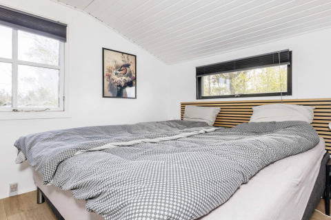 Lichte slaapkamer in een vakantiewoning in Løgstør, Denemarken, met tweepersoonsbed en grote ramen.