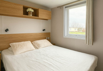 Bedroom at Holiday home (PL. 94) in Camping Papillon, Belgium, featuring a double bed and a large window.