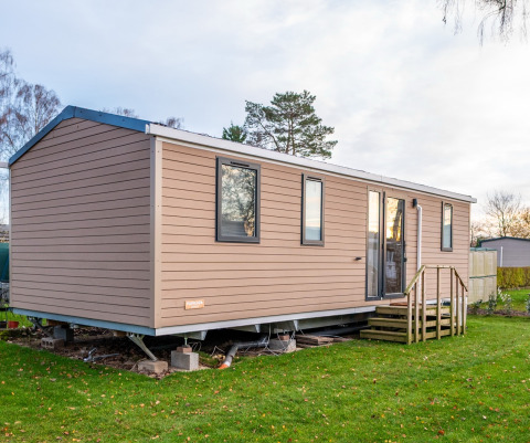 Foto van een moderne chalet bij Holiday home (PL. 94) met houten bekleding en trapje.