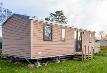 Billede af et feriehus ved Holiday home (PL. 94) med træbeklædning og lille trappe indgang.