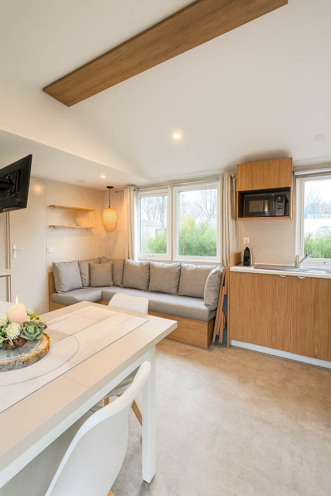 Gezellige leefruimte en keuken in Holiday home (PL. 94) op Camping Papillon te België met ruime zithoek en licht.