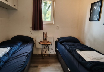 Chambre au lodge Hackfort à Kaatsheuvel, Pays-Bas, avec deux lits simples et des tableaux muraux.