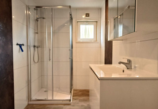 Modern bathroom at Hackfort Lodge in Kaatsheuvel, Netherlands, featuring a shower and sleek white interior.
