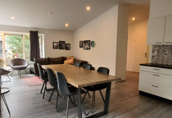 Moderne eet- en woonkamer in de Hackfort lodge te Kaatsheuvel, Nederland, met open keuken.