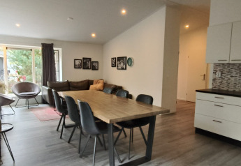 Moderne eet- en leefruimte in de Hackfort lodge in Kaatsheuvel, Nederland, met open keuken.