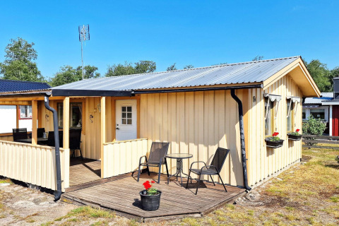 Casa vacanze gialla per 5 persone a Skummeslövsstrand con veranda, set da giardino e fioriere.