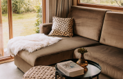 Knusse woonkamer met hoekzetel, sierkussen en plaid in Klapkot, De Achterste Hoef, Nederland.
