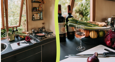 Cuisine chaleureuse dans une cabane avec fenêtres ouvertes, légumes frais, bouteilles de vin et planche à découper.