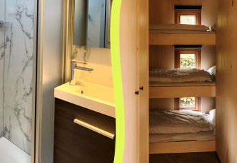 Photo d'une salle de bain en cabane avec aspect marbre et coin nuit avec trois lits superposés et fenêtres.