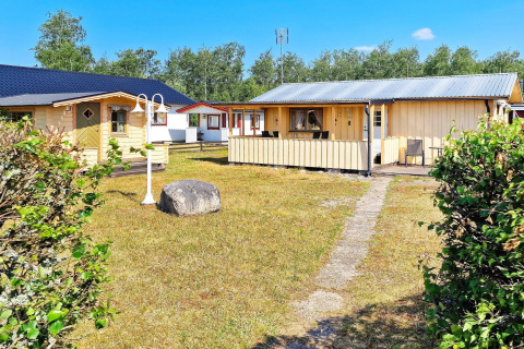 Casa vacanze a Skummeslövsstrand, Svezia, con casette gialle, prato e cielo azzurro e soleggiato.