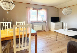 Bright living and dining area in a holiday home in Skummeslövsstrand, Sweden, with a TV and cozy decor.