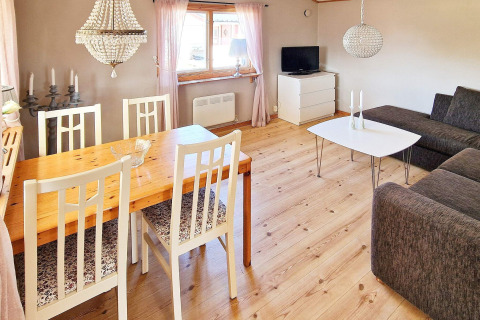 Helles Wohnzimmer im Ferienhaus in Skummeslövsstrand, Schweden, mit Esstisch, Sofa und TV-Ecke.