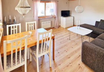 Gezellige leefruimte met eet- en zithoek in vakantiehuis in Skummeslövsstrand, Zweden, met modern interieur.