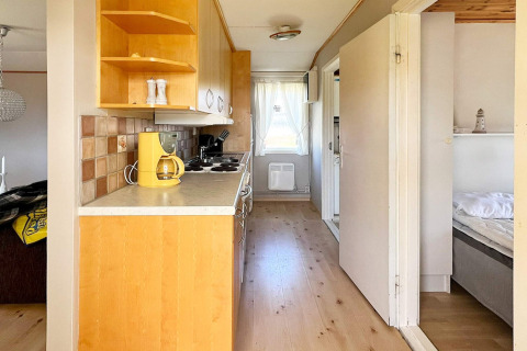 Schmaler Flur mit Küche in einem 5-Personen-Ferienhaus in Skummeslövsstrand, Schweden.
