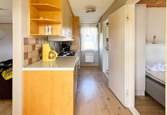 Schmaler Flur mit Küche in einem 5-Personen-Ferienhaus in Skummeslövsstrand, Schweden.