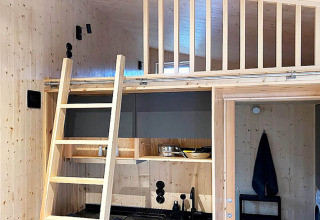 Interno di una casa vacanze 4 stelle a Höllviken, Svezia, con soppalco, scala e cucina moderna.