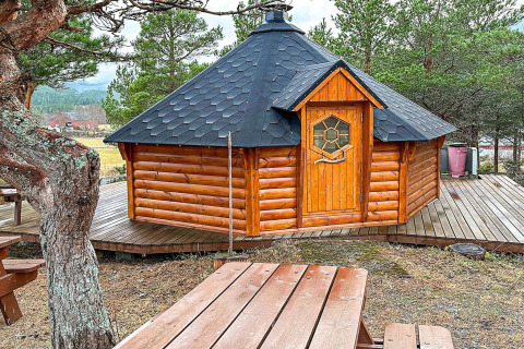 Accogliente yurta di legno con tetto nero su terrazza, casa vacanze a Lysøysundet, Svezia.