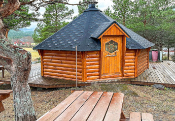 Accogliente yurta di legno con tetto nero su terrazza, casa vacanze a Lysøysundet, Svezia.