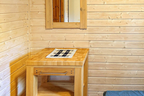 Houten tafel met spiegel aan houten wand in 4-persoons vakantiehuis in Lysøysundet, Zweden.