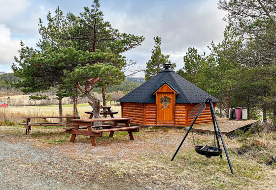 Vista exterior de una yurta de madera, bancos de picnic y fogata en casa de vacaciones para 4 en Lysøysundet.