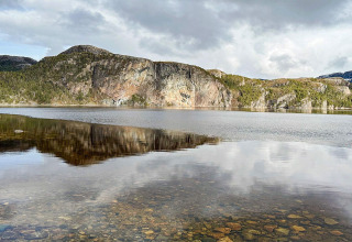 Foto eines klaren Sees mit Bergen und Spiegelung, aufgenommen bei einer Jurte in Lysøysundet, Schweden.