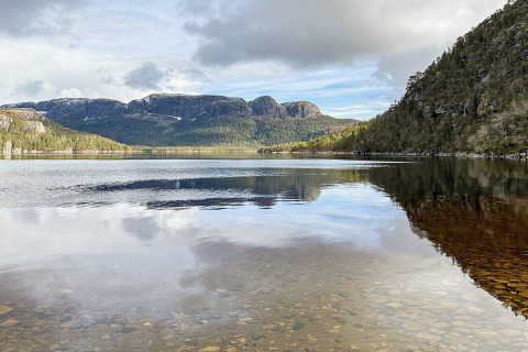 Wunderschöner Blick vom Ferienhaus in Lysøysundet, Schweden, auf klaren See und bewaldete Berge.