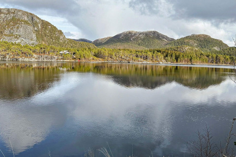 Prachtig uitzicht op bergen, bos en meer vanaf een yurt bij Lysøysundet, Zweden op een bewolkte dag.