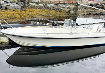 Pequeña lancha amarrada junto a una yurta en Lysøysundet, Suecia, reflejada en aguas tranquilas.